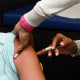 Medical Assistant gives a flu shot to a child at pediatric office.